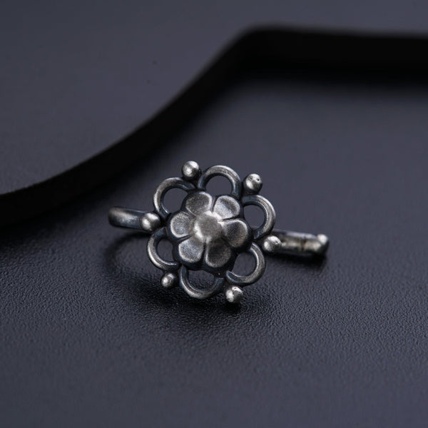 a silver ring sitting on top of a black surface