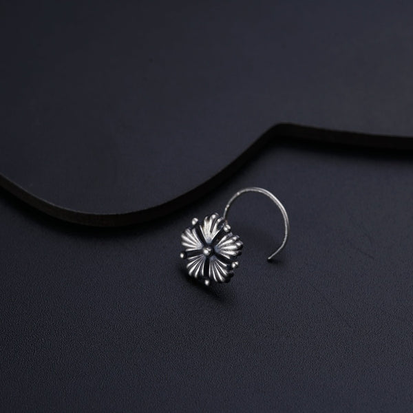a pair of earrings sitting on top of a black surface
