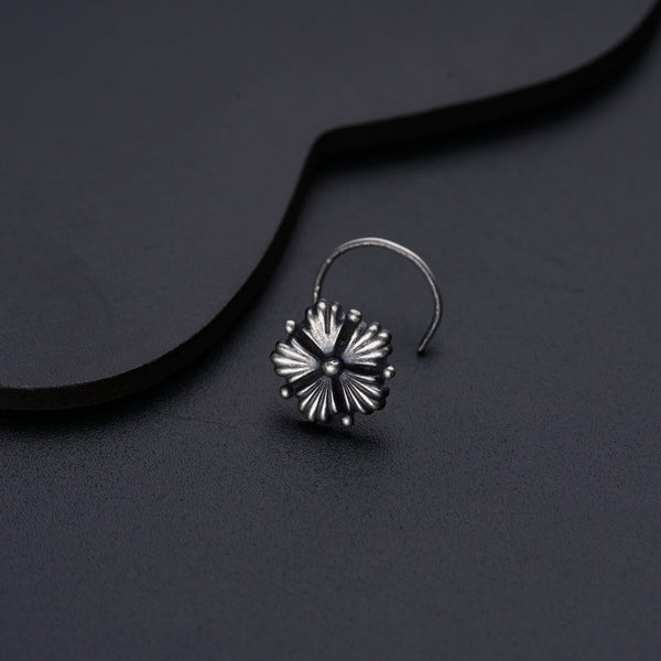 a pair of silver hoop earrings on a black surface