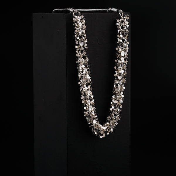 a necklace is displayed on a black stand