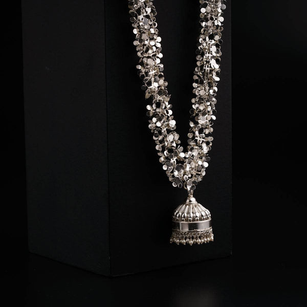 a necklace with a bell on a black background