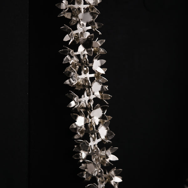 a metal object hanging from a black wall