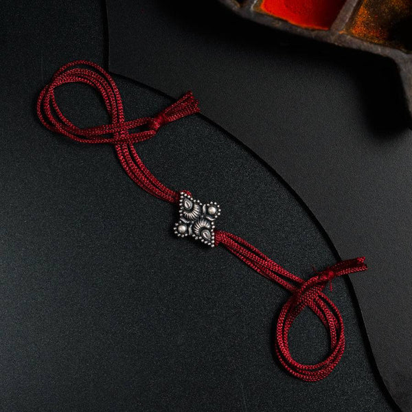 a red string with a cross on it