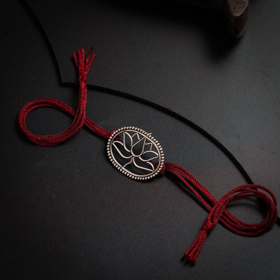 a red cord with a silver flower on it