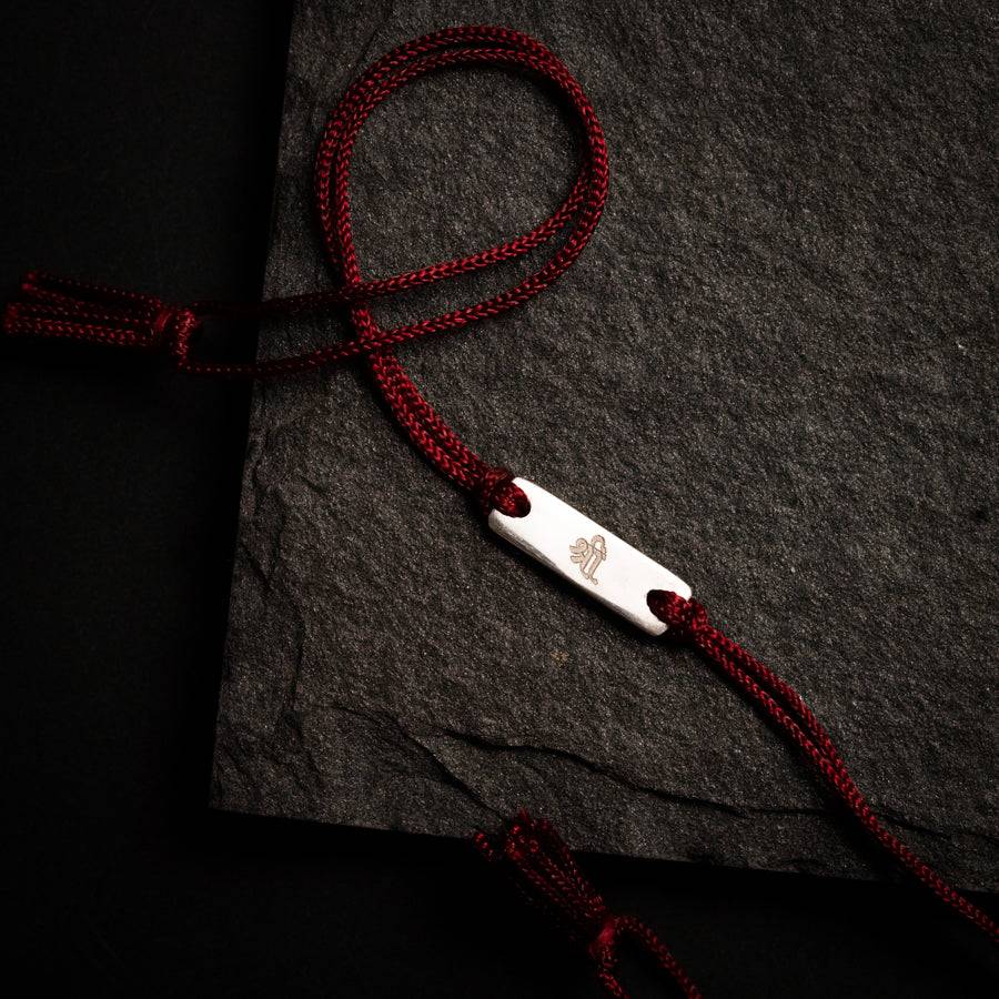 a red rope is attached to a black piece of paper