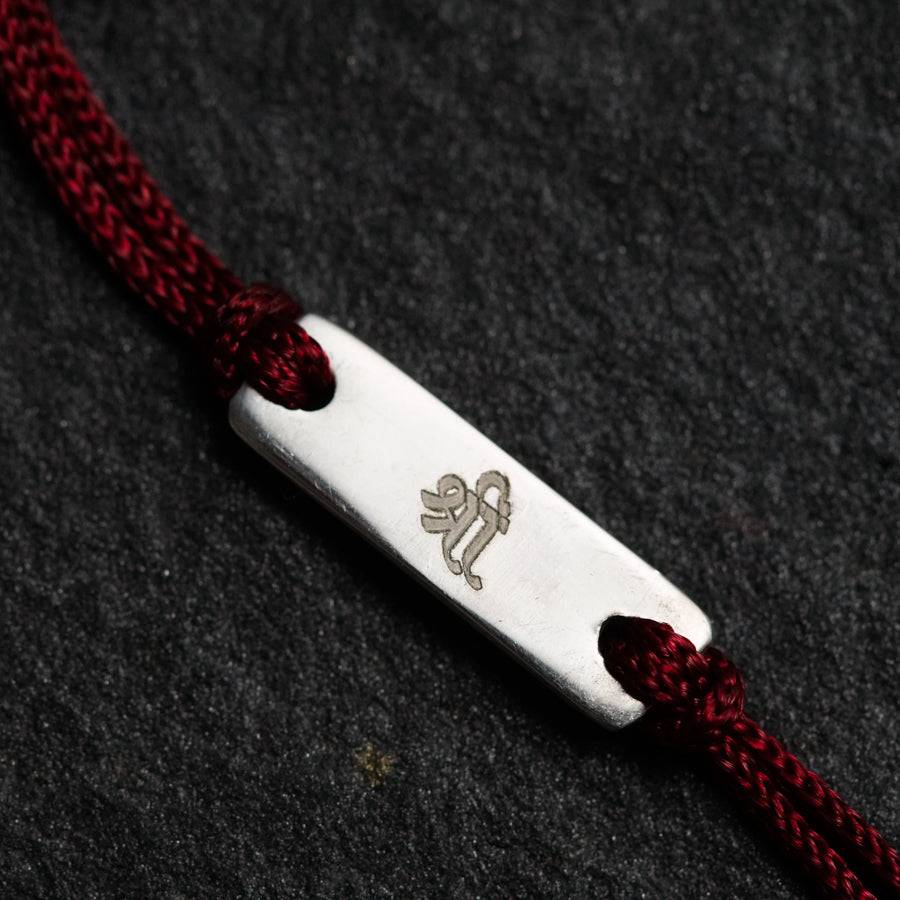 a close up of a red rope with a silver object on it