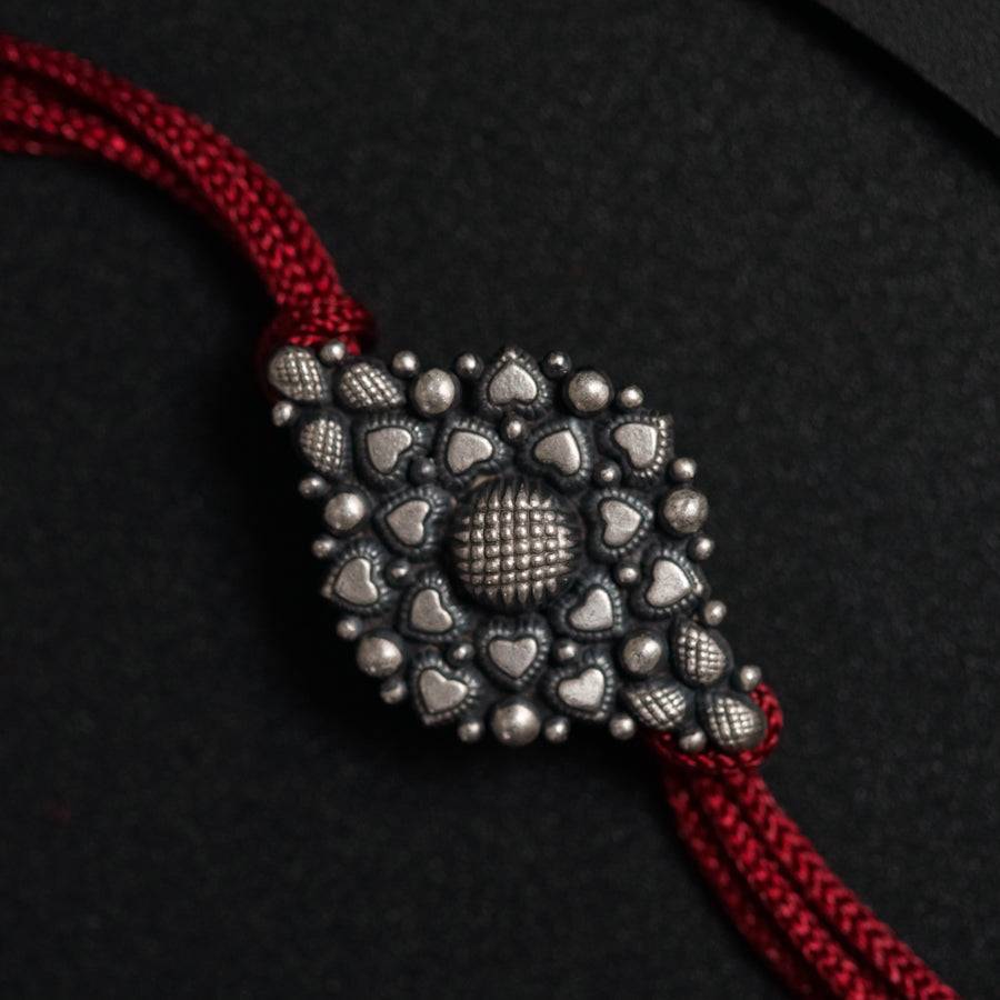 a close up of a red string with silver beads