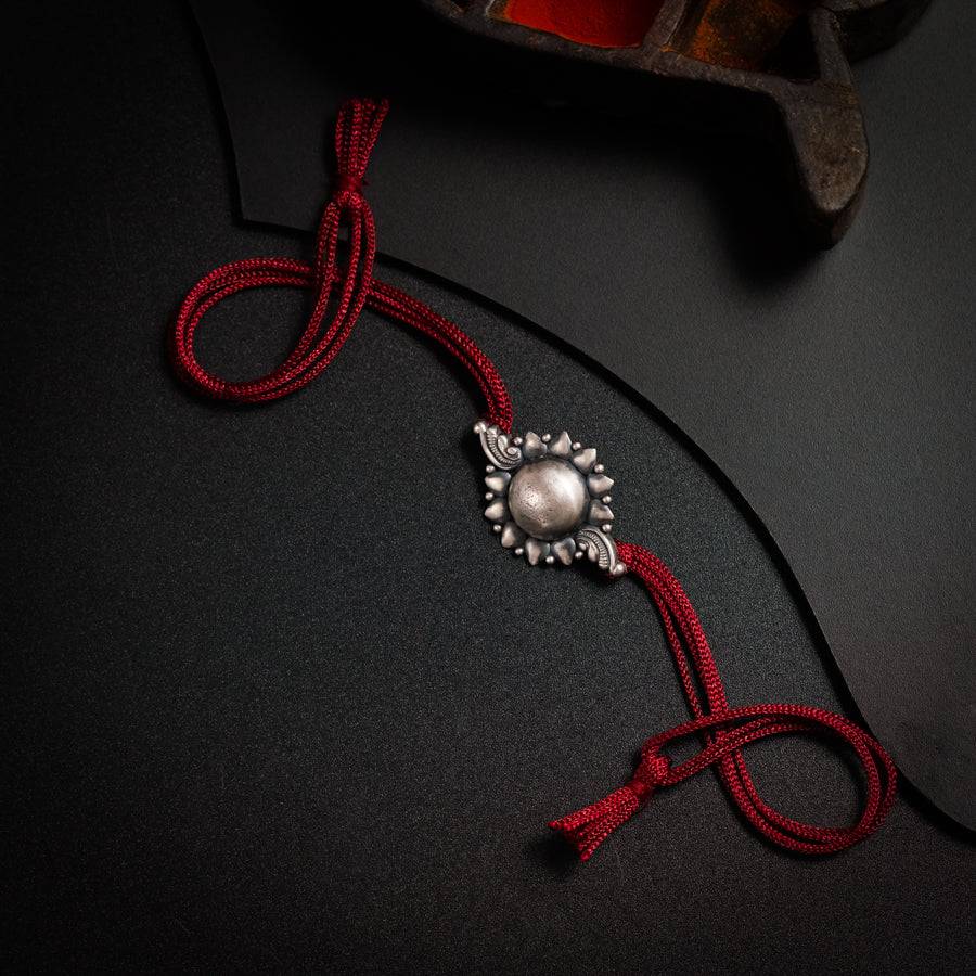 a red string with a silver bead on it