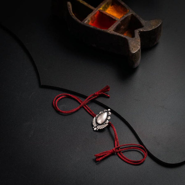 a red cord with a white bead on it