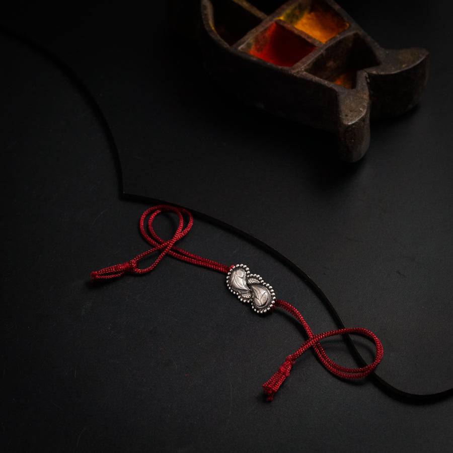 a black table with a red cord and a silver object on it