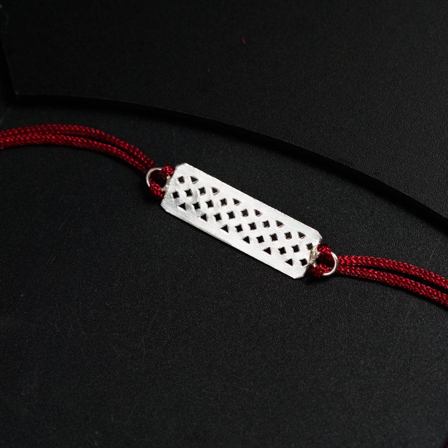 a white and red necklace with a black and white design on it