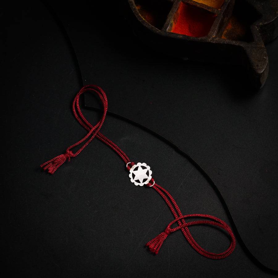 a red string with a white bead on it