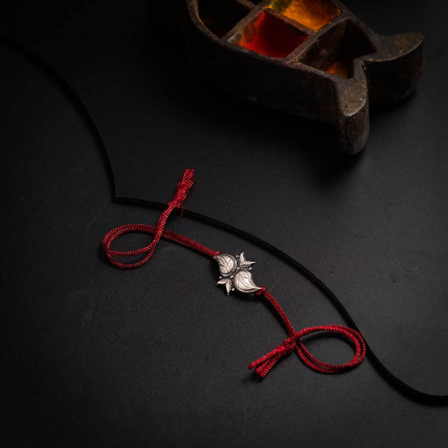 a red string with a silver flower on it