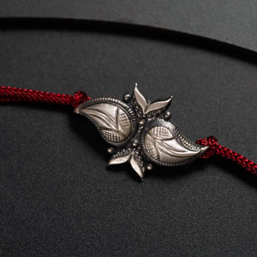 a red cord with a silver flower on it