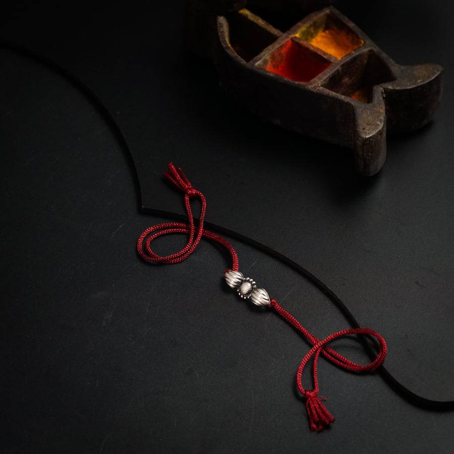 a red string with two silver beads on it