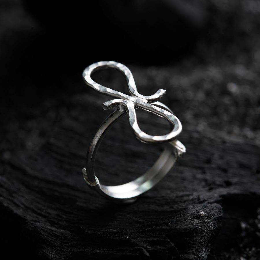 a close up of a silver ring on a black surface