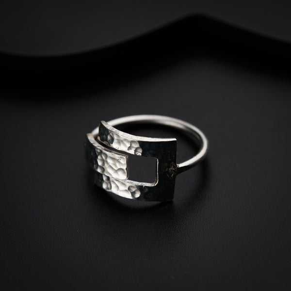 a silver ring sitting on top of a black surface
