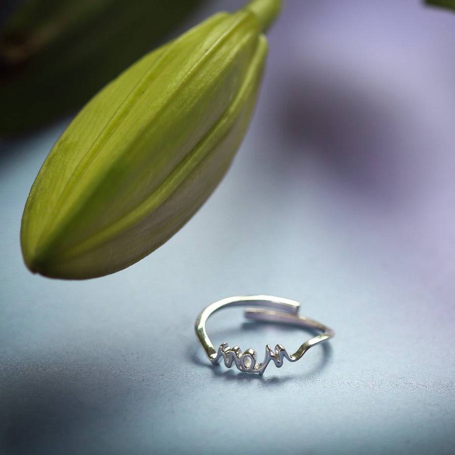 a close up of a ring with a flower in the background