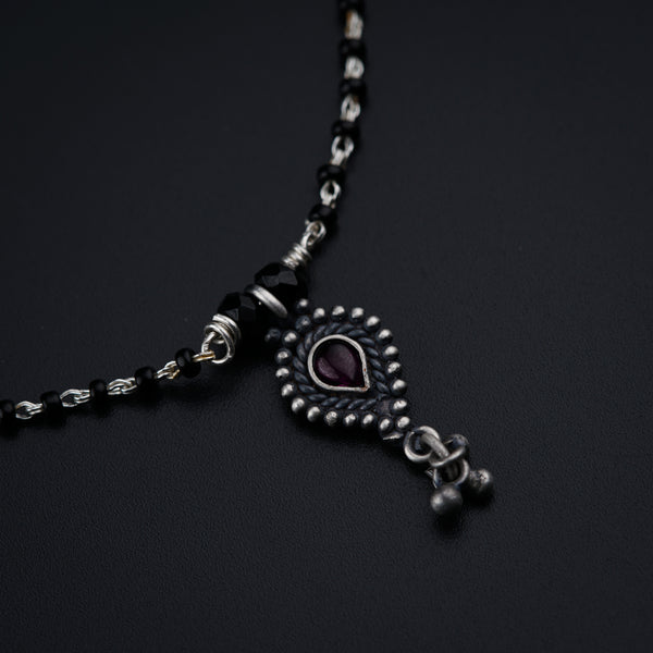 a black and silver necklace with a heart on it