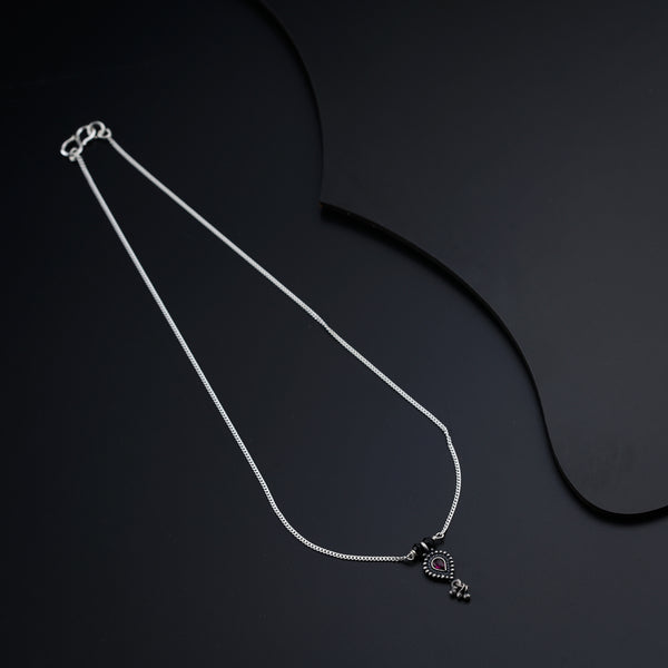 a necklace with a heart on a black background