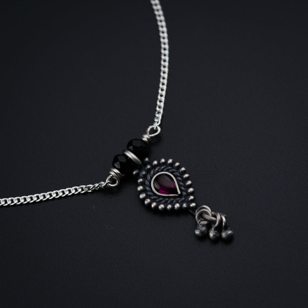 a black and silver necklace with a heart on it
