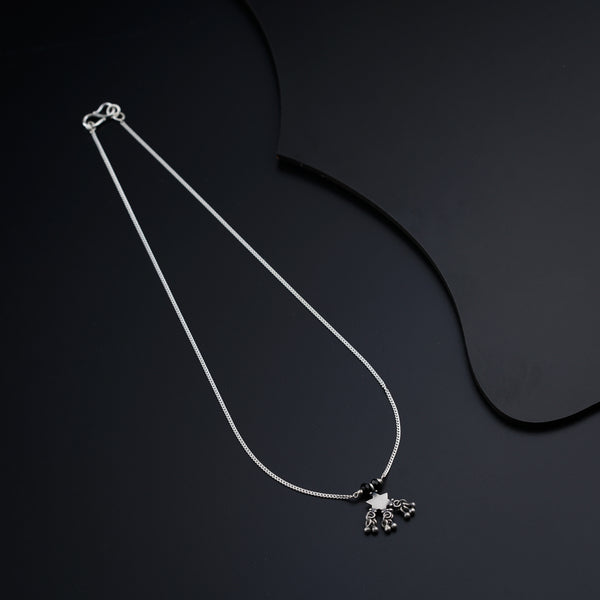 a black and white photo of a necklace on a black background