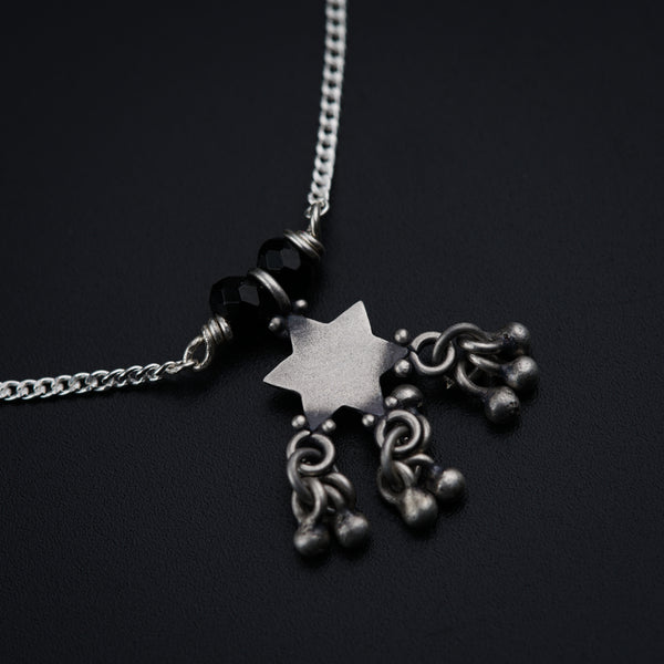 a silver necklace with a star on it