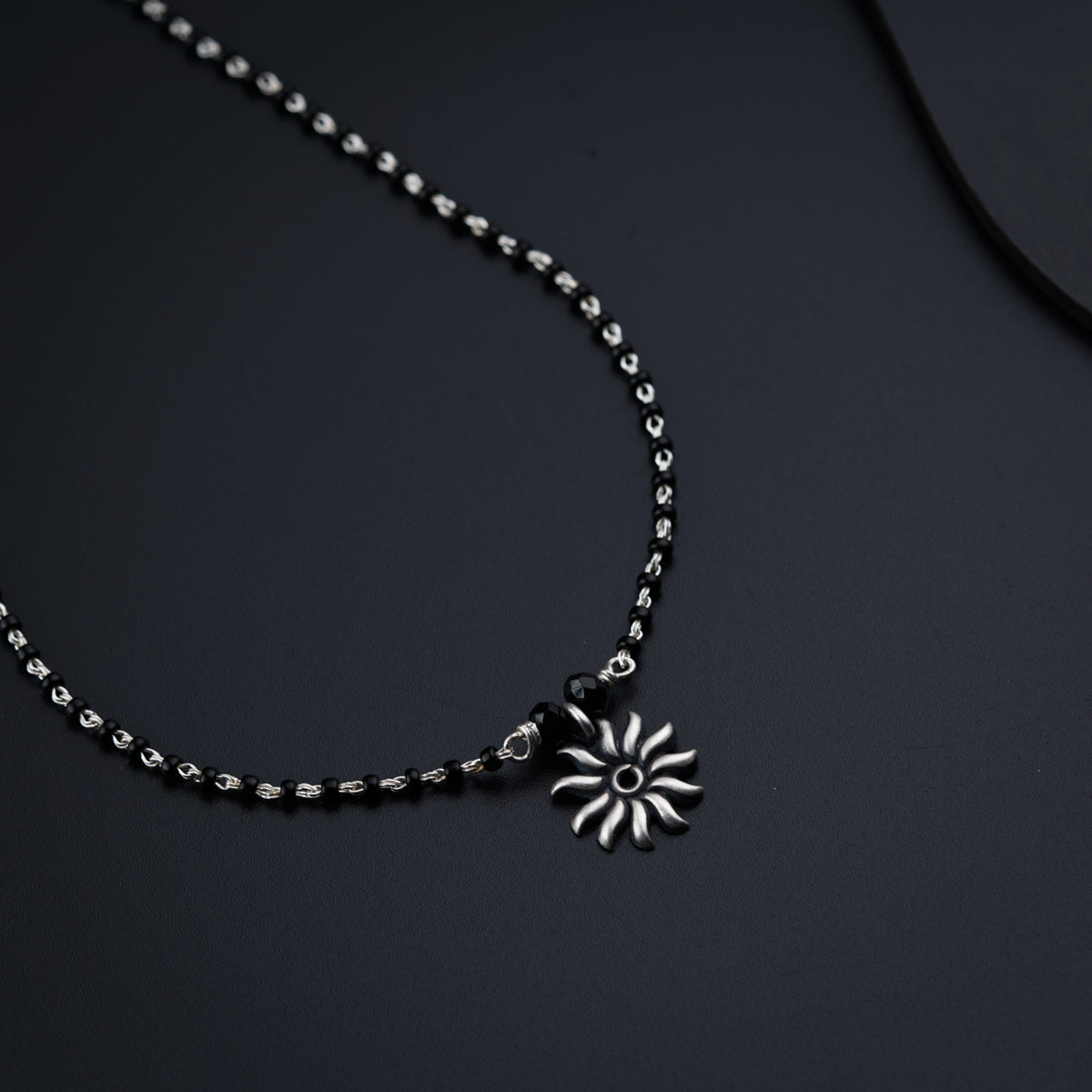 a necklace with a flower on a chain