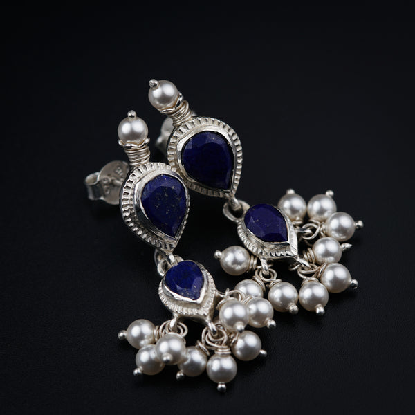 a close up of a pair of earrings on a black surface