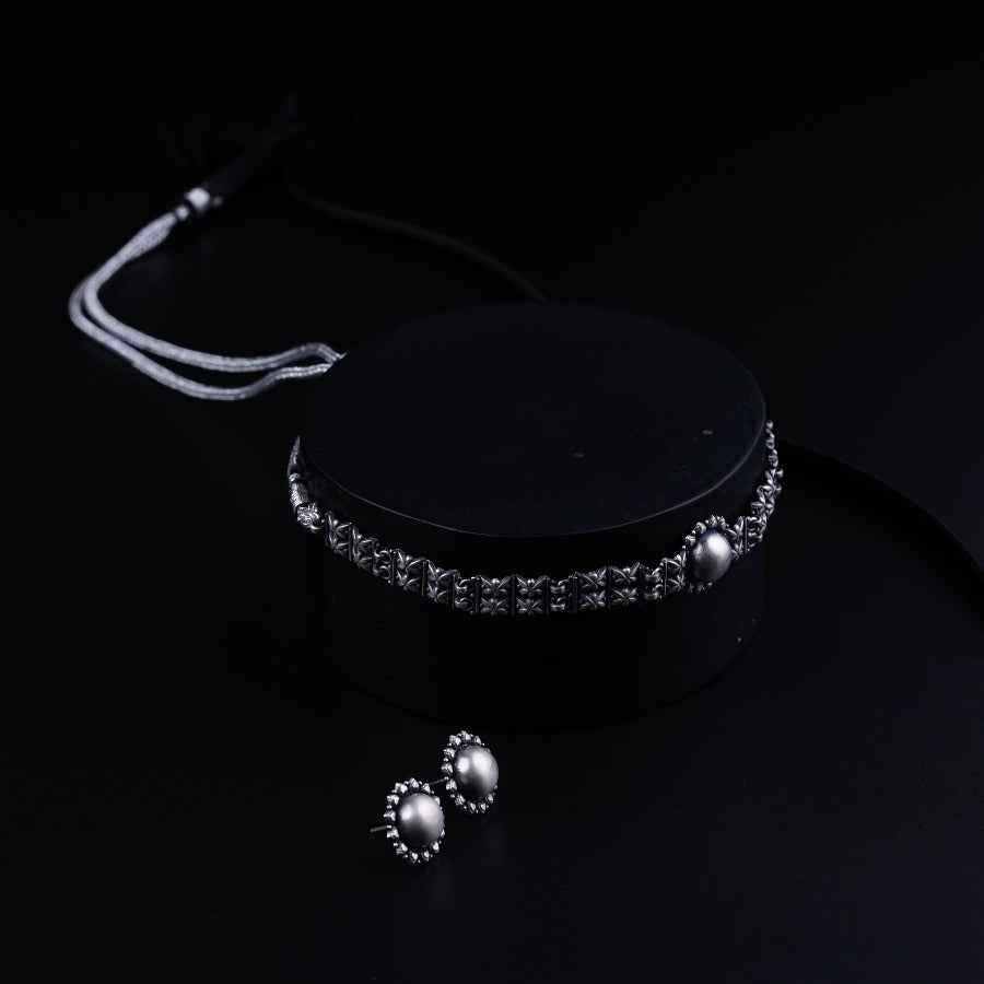 a black box with a necklace and earrings on it