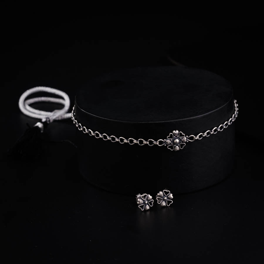 a choker and earring on a black surface
