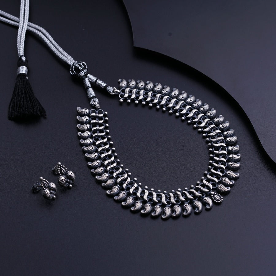 a necklace and earring set with a tassel