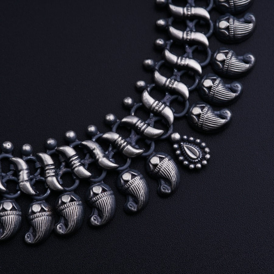 a black necklace with silver details on a black background