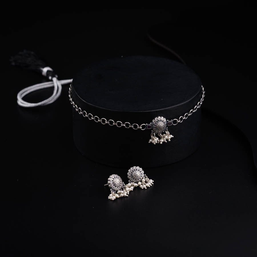 a pair of silver jewelry on a black surface