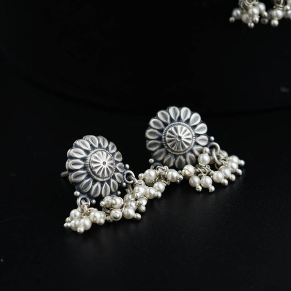 a close up of a pair of earrings on a black surface