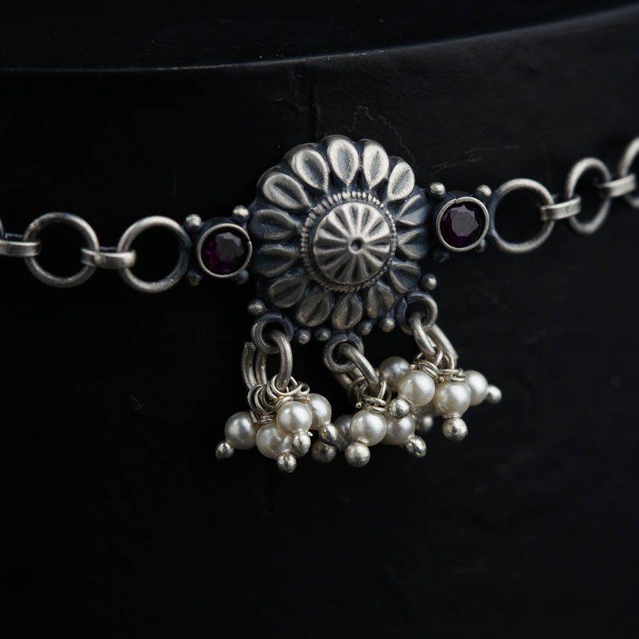 a close up of a necklace with pearls