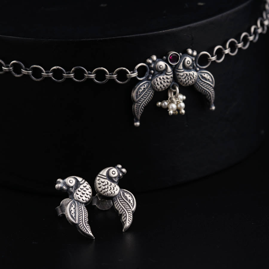 a necklace with two birds on it