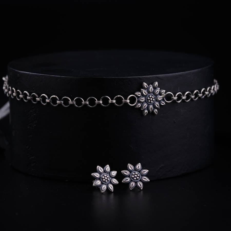 a black hat with two silver flowers on it