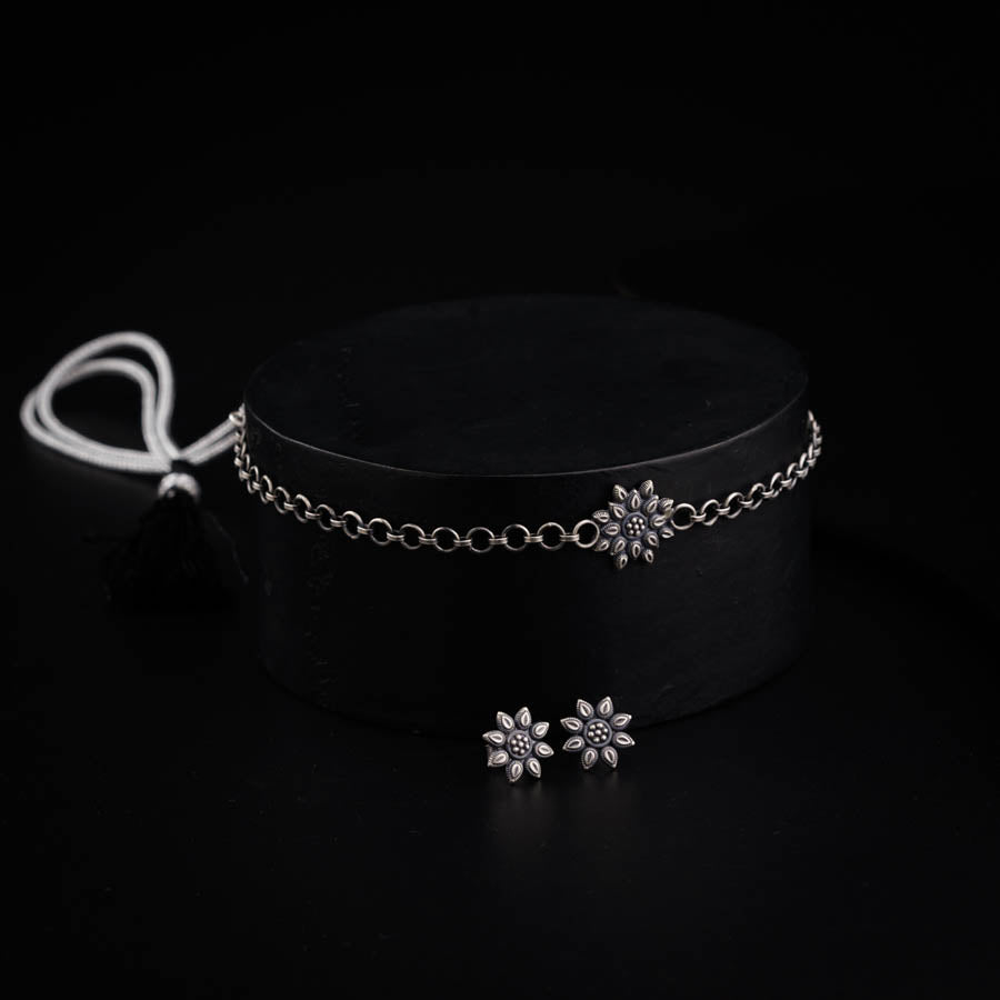 a choker with a flower charm on a black background