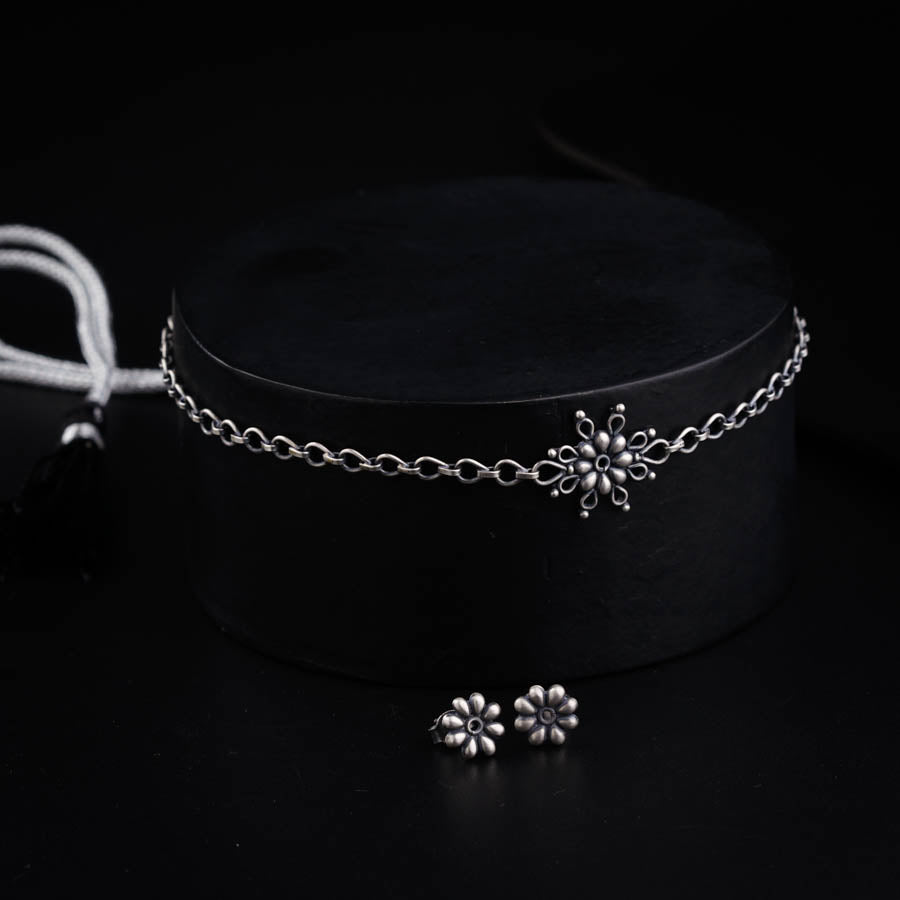 a black hat with a silver flower on it