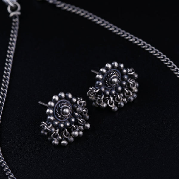 a close up of a pair of earrings on a chain