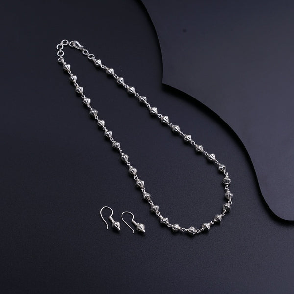 a necklace and earring on a black surface