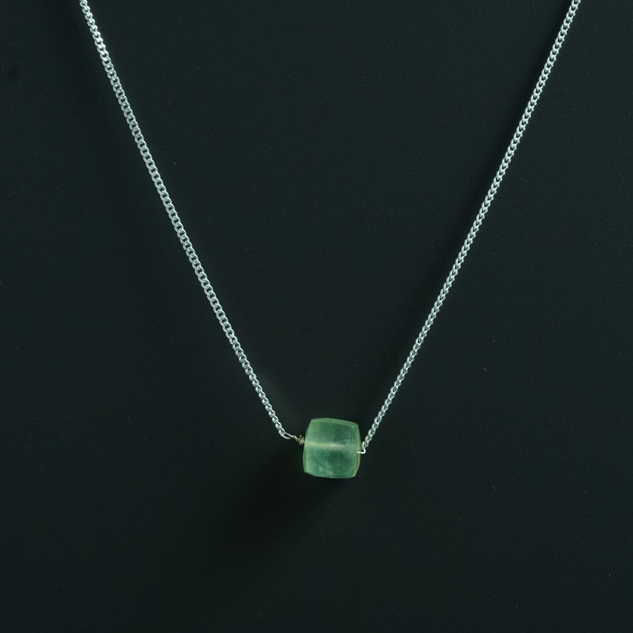 a necklace with a green stone on a chain