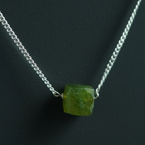 a necklace with a green stone on it