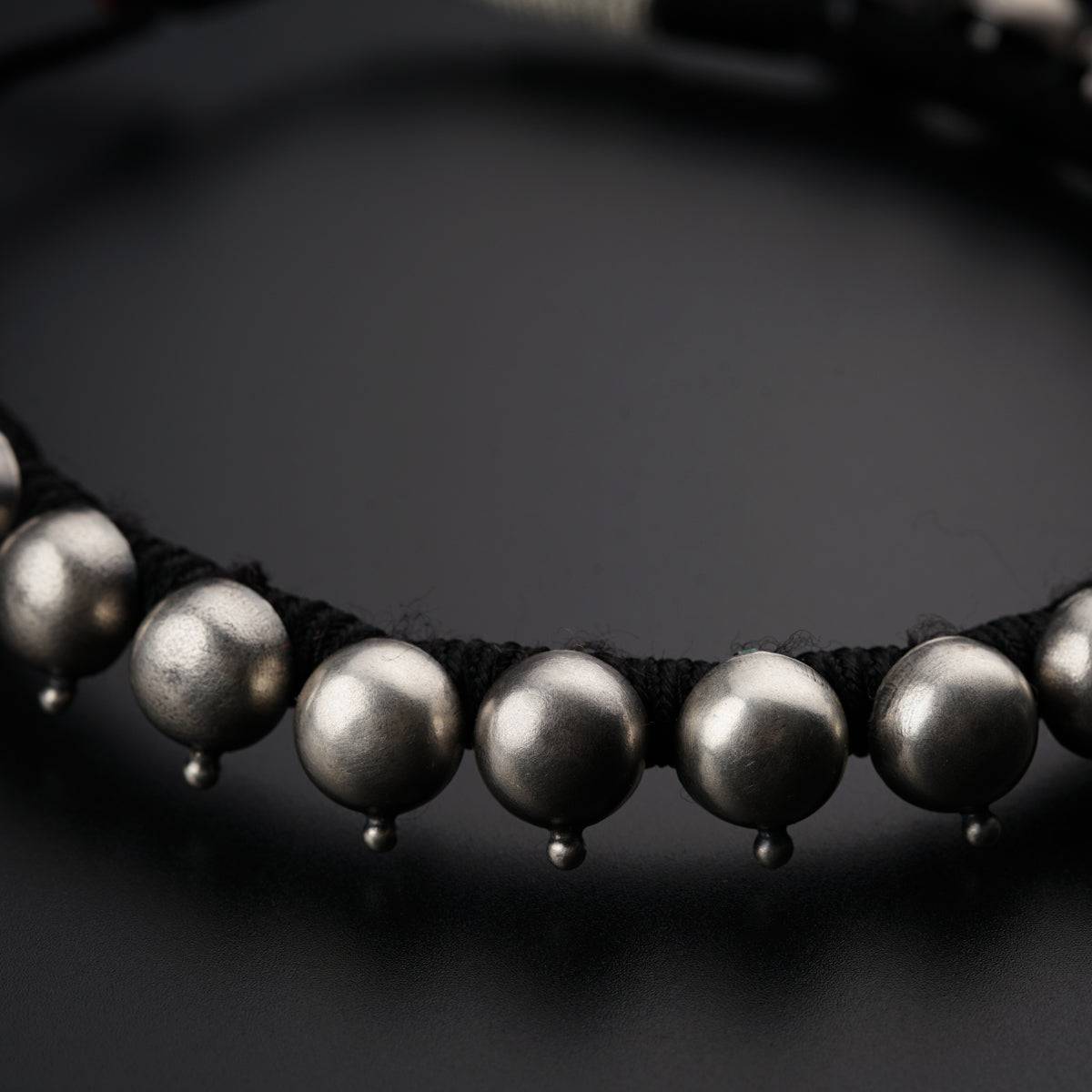 a close up of a necklace on a black surface