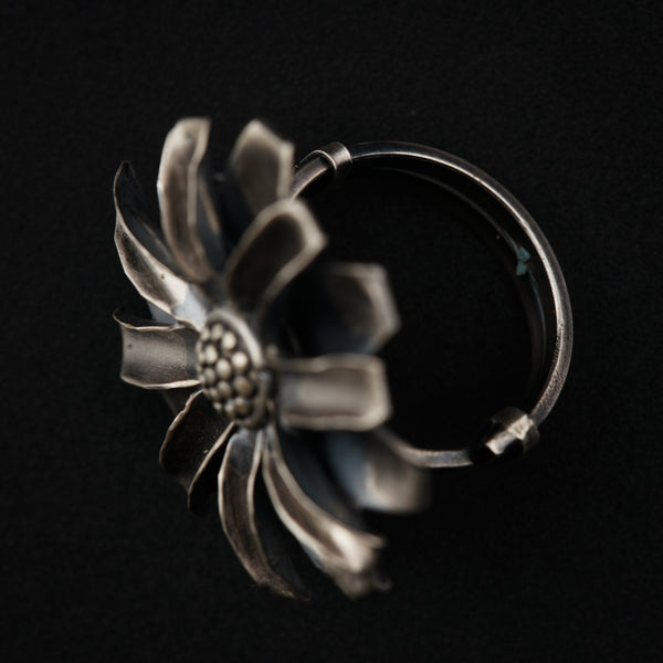 a silver ring with a flower on it