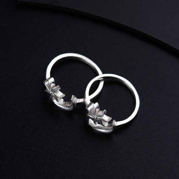 a pair of silver rings on a black surface