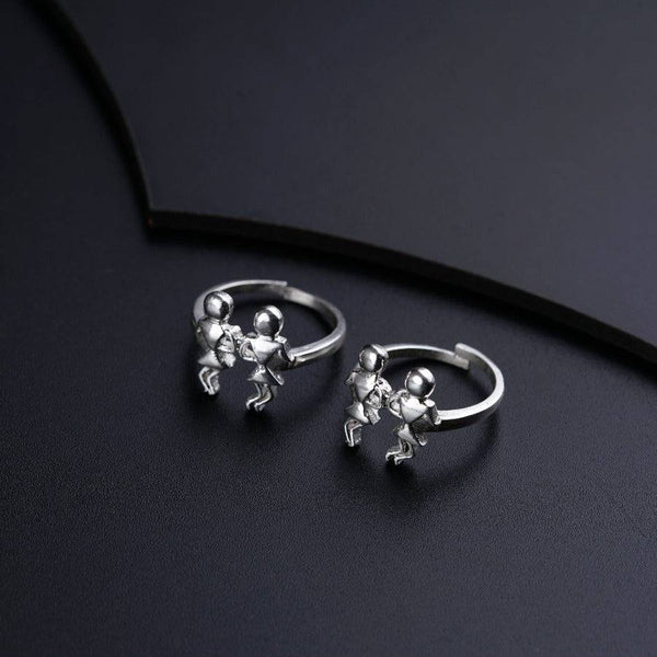a pair of silver earrings sitting on top of a black surface