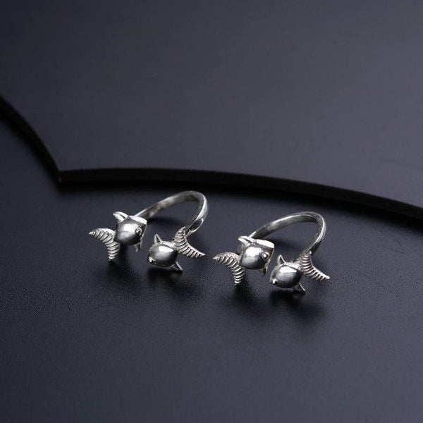 two silver birds on a black surface