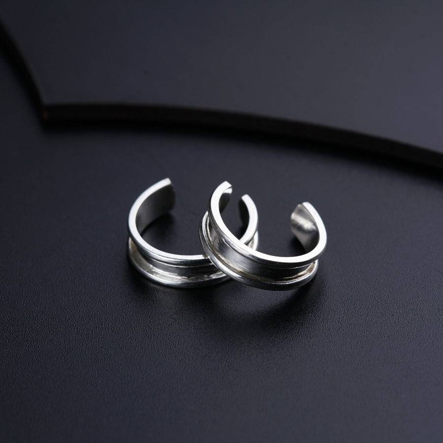 two silver rings sitting on top of a black surface